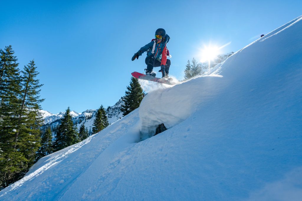 Snowboarder gleitet über die verschneite Piste am Hündle