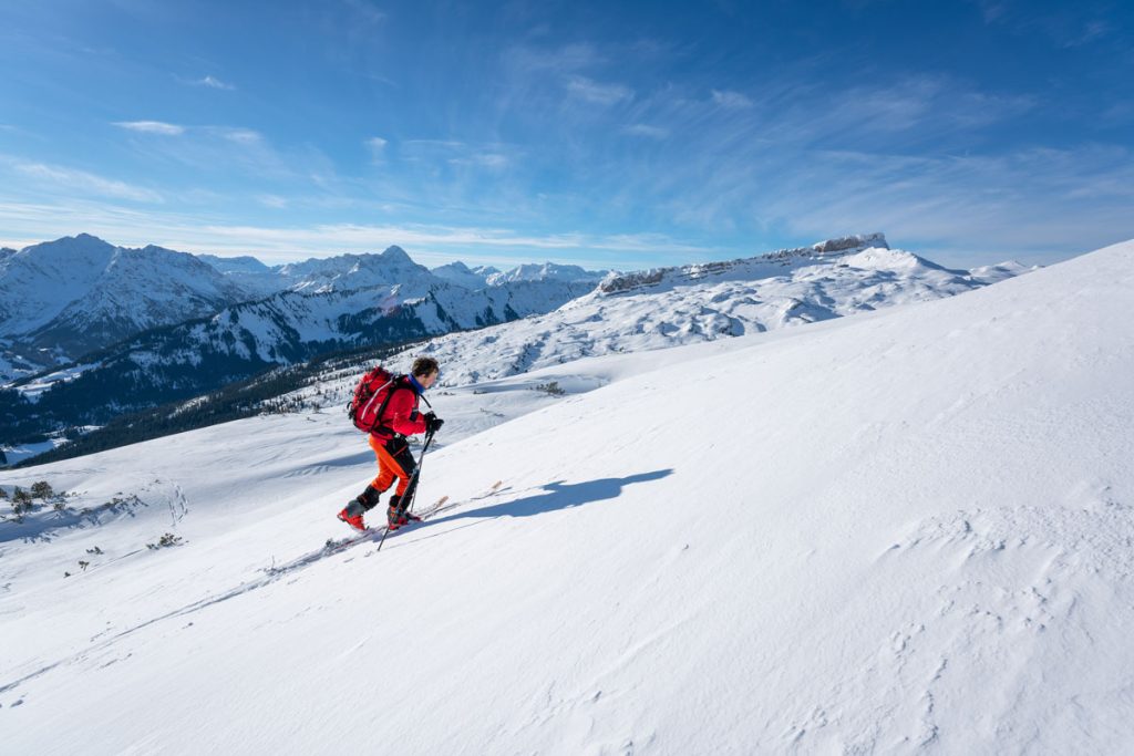 „Person spaziert auf präpariertem Winterweg mit Winterpanorama in Oberstaufen
