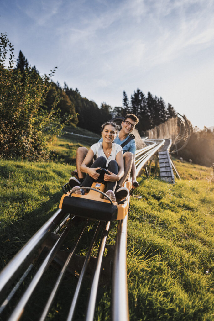 Jugendliche in der Sommerrodelbahn der Alpsee Bergwelt.