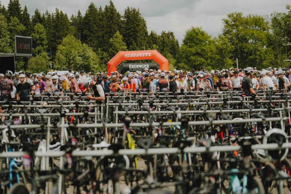 Hunderte Rennräder stehen geordnet in den Fahrradständern auf dem Eventgelände des Radrace One-Twenty vor dem SRAM-Zielbogen.