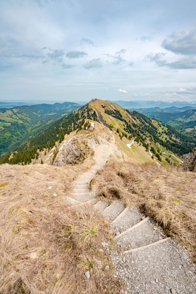 Blick hinab auf den alpinen Premiumwanderweg mit Stufen entlang des Bergkamms am Hochgrat im Allgäu.