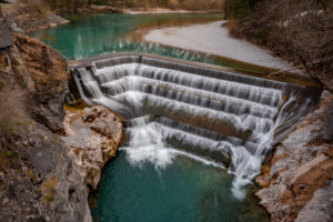 Tosendes, türkisblaues Wasser fließt über die fünfstufige Felsschwelle des Lechfalls in Füssen.